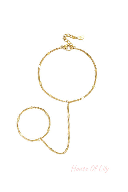 Delicate gold chain hand bracelet with small shimmering discs and adjustable lobster clasp