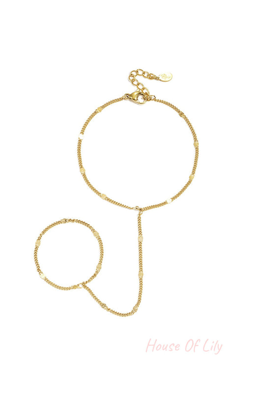 Delicate gold chain hand bracelet with small shimmering discs and adjustable lobster clasp