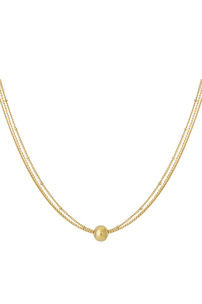 Gold layered necklace with small beads and a smooth round pendant on a white background