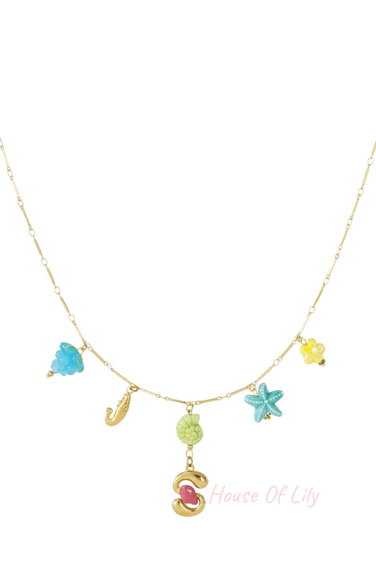 Gold chain necklace with colorful coastal charms including a sea shell, starfish, and gold letter S initial pendant.
