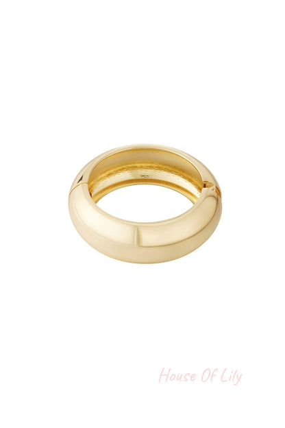 Chunky smooth gold-tone hinged bangle bracelet on white background