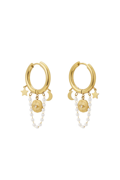 Pair of gold celestial charm hoop earrings with star, moon, sun motifs and pearl chain charms displayed on white background