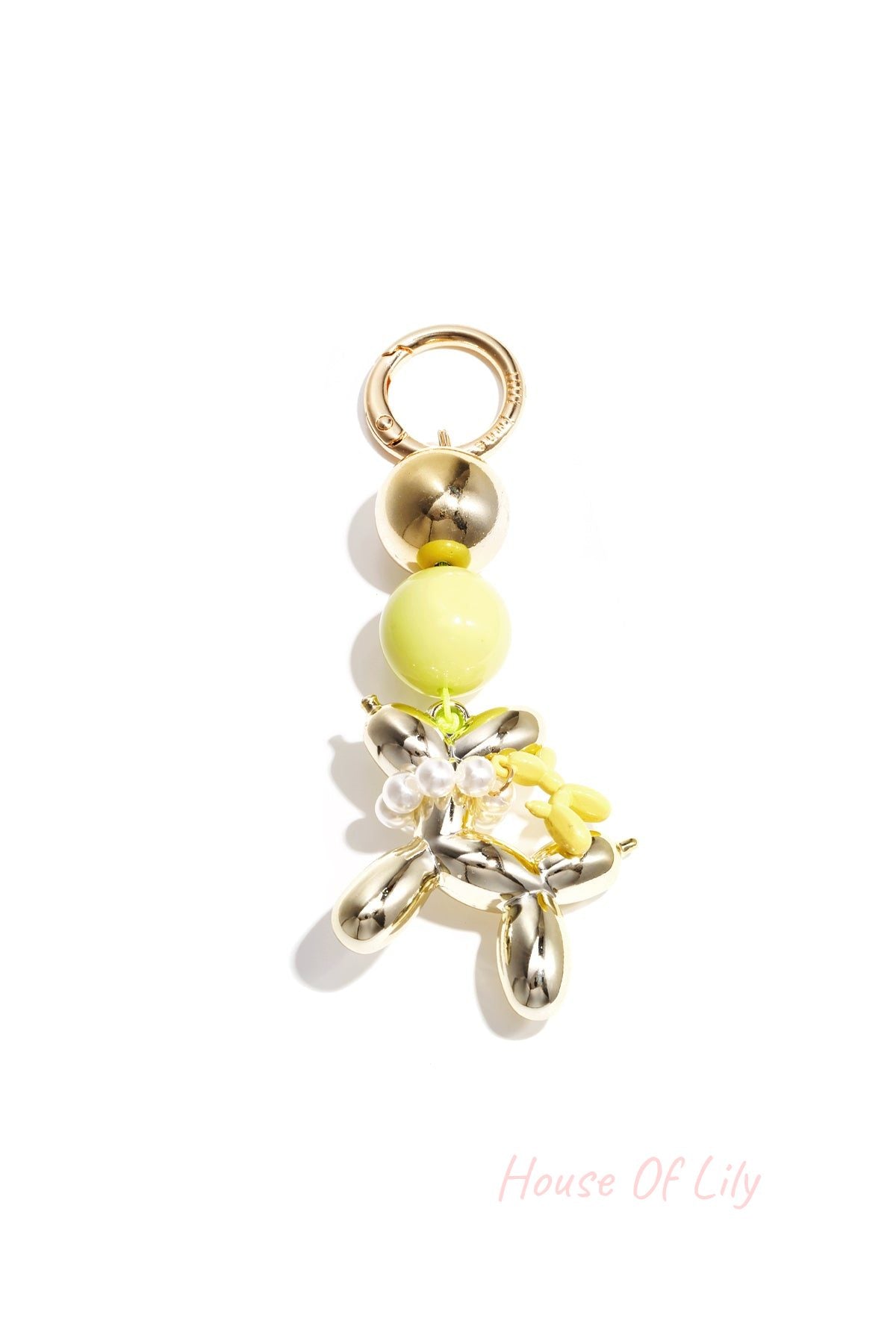Gold-tone balloon dog keychain with yellow acrylic bead and matching small yellow balloon charm on white background