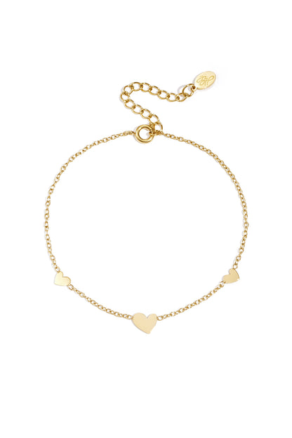 Gold chain bracelet with three small heart-shaped charms evenly spaced along the chain on white background