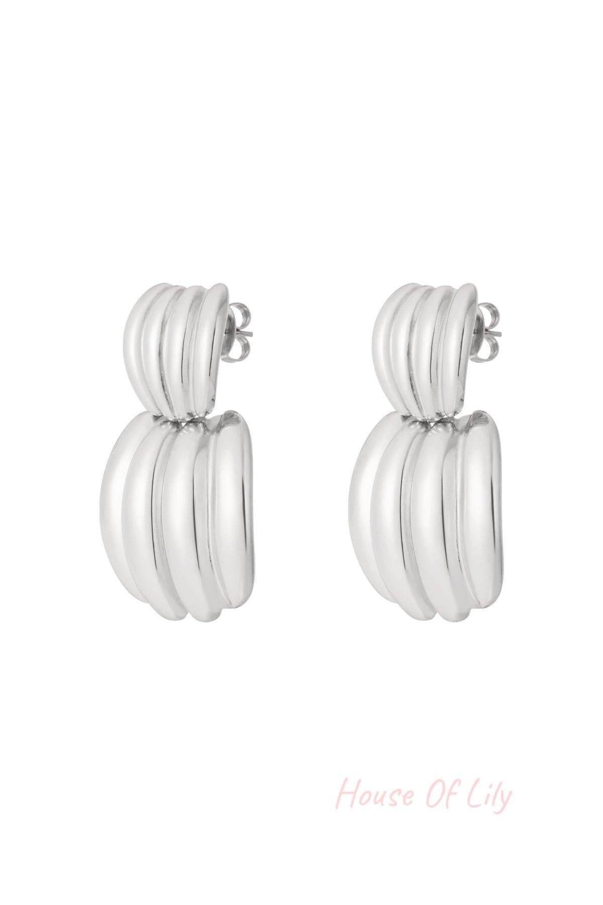 Pair of polished silver chunky hoop earrings with ribbed texture on white background