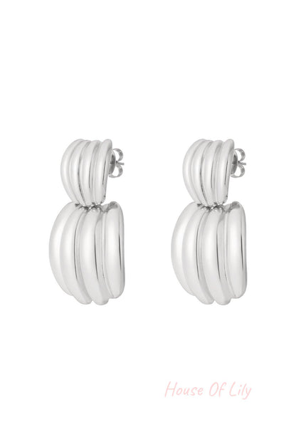 Pair of polished silver chunky hoop earrings with ribbed texture on white background