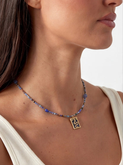 Necklace with a pendant worn by a person on a plain background