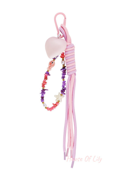 Pink and purple heart bag charm with colorful beads and tassel on white background