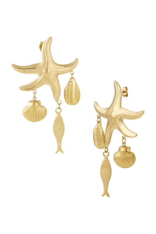 Pair of gold starfish dangle earrings with small hanging charms shaped like a fish, scallop shell, and cowrie shell on a white background