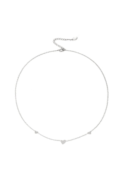 Silver heart charm chain necklace on white background