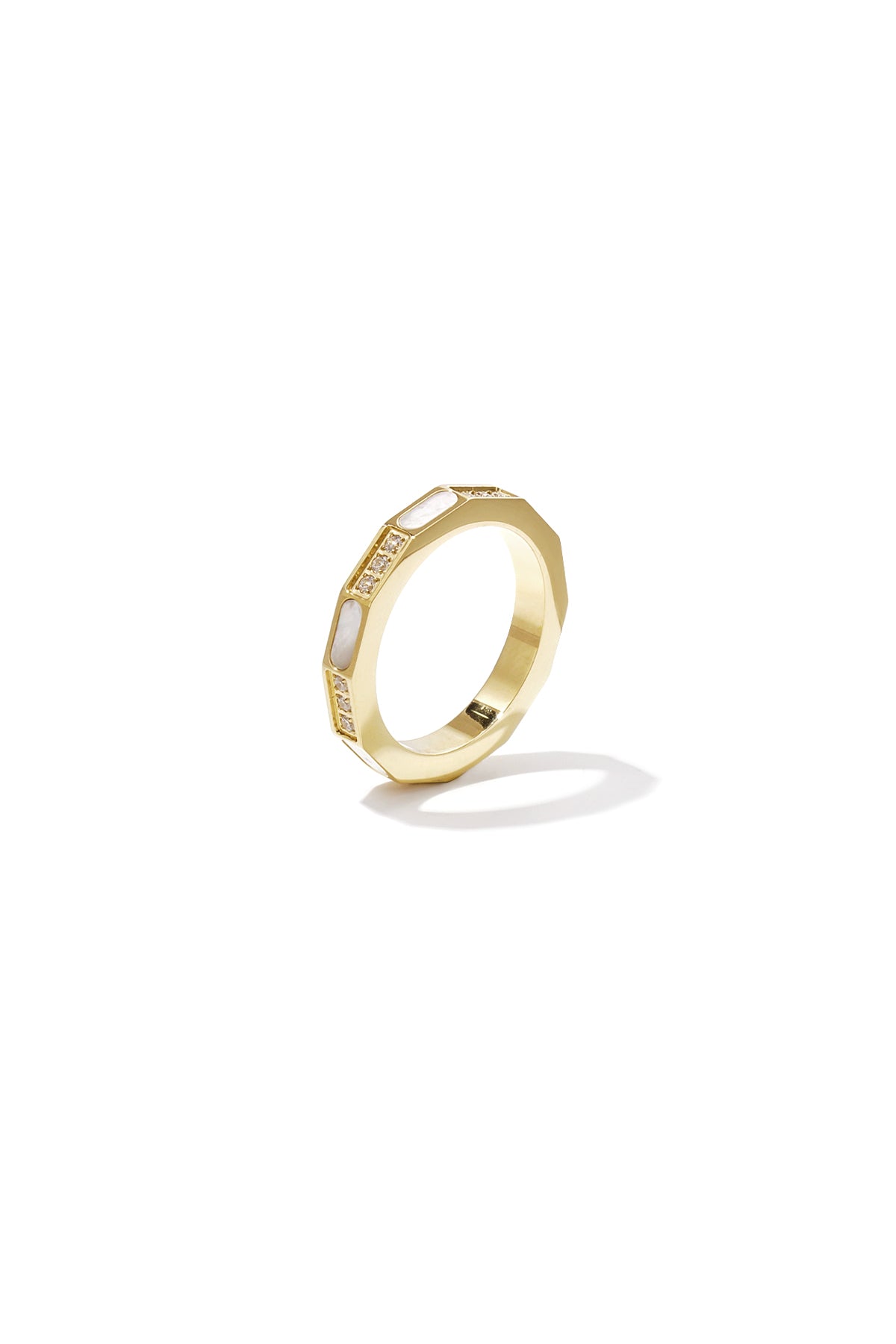 Close-up of a gold geometric ring with mother-of-pearl inlays and zircon stones on white background