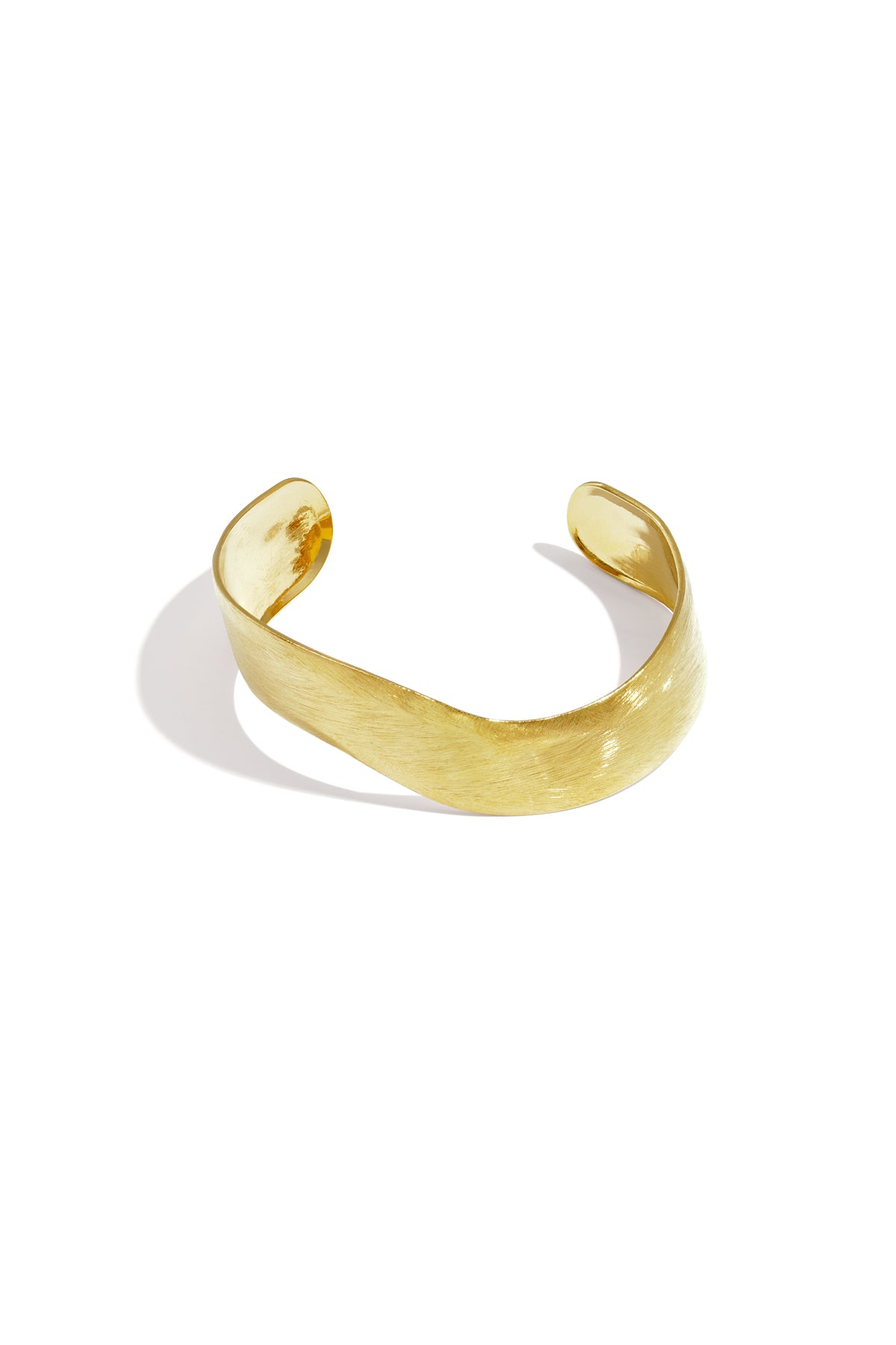 Gold curved minimalist cuff bracelet with a brushed texture finish on a white background