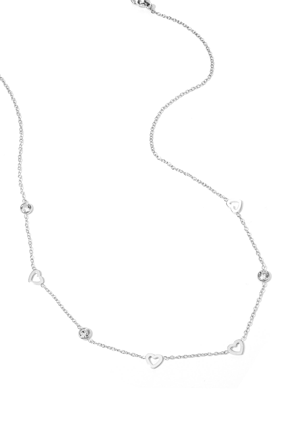 Front view of a woman wearing the gold heart charm necklace paired with gold hoop earrings, showcasing the subtle sparkle