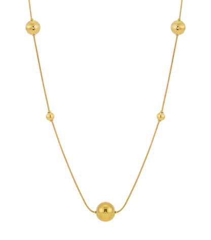 Close-up of a long gold bead necklace with polished spheres spaced evenly on a fine chain