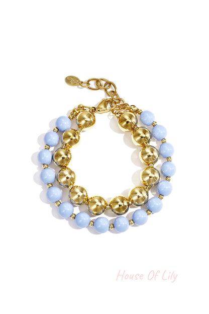 Double layered bracelet with light blue acrylic and gold-tone beads on white background