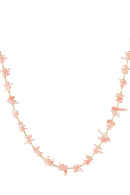Close-up of pink coral chip necklace with gold rods on white background