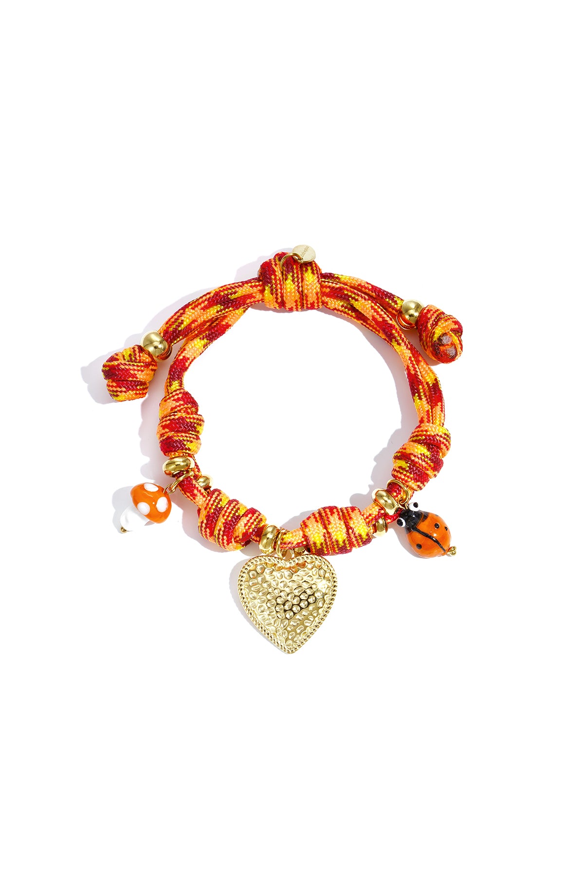 Colorful orange-red knotted rope charm bracelet with a gold textured heart pendant, mushroom and ladybug charms.