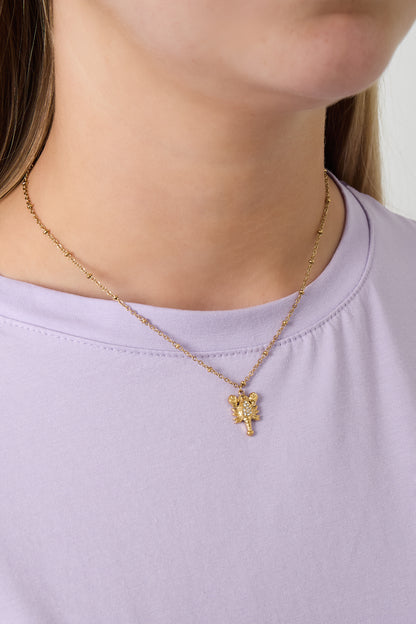 Close-up of woman wearing gold lobster charm necklace with purple shirt showing the necklace styling and fit
