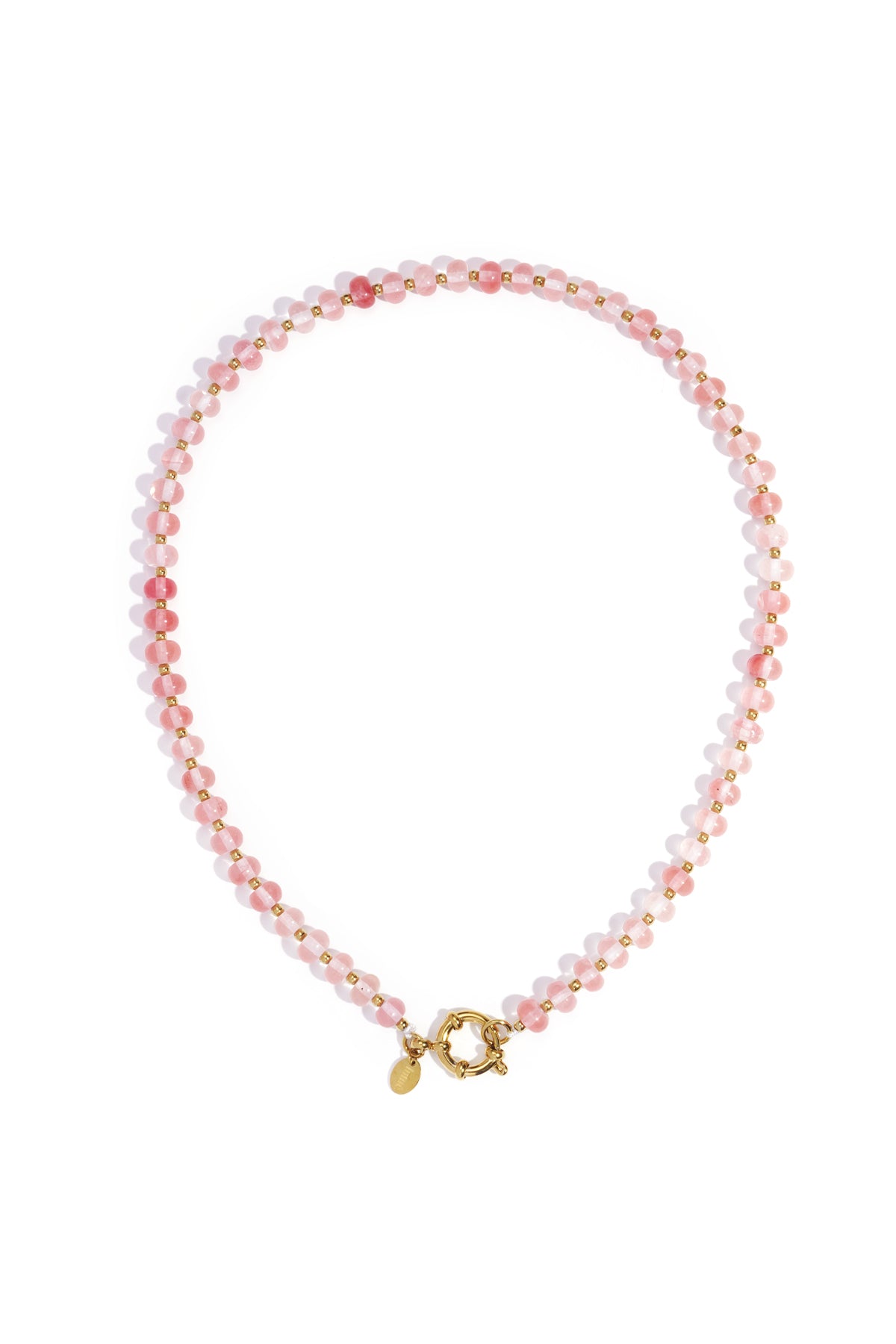 Close-up of a pale pink stone beaded necklace with gold beads and toggle clasp