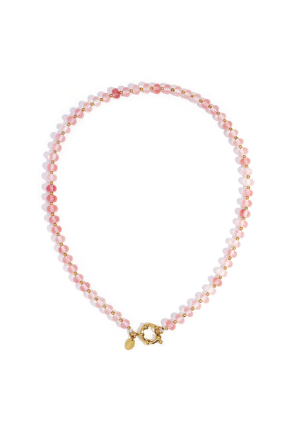 Close-up of a pale pink stone beaded necklace with gold beads and toggle clasp