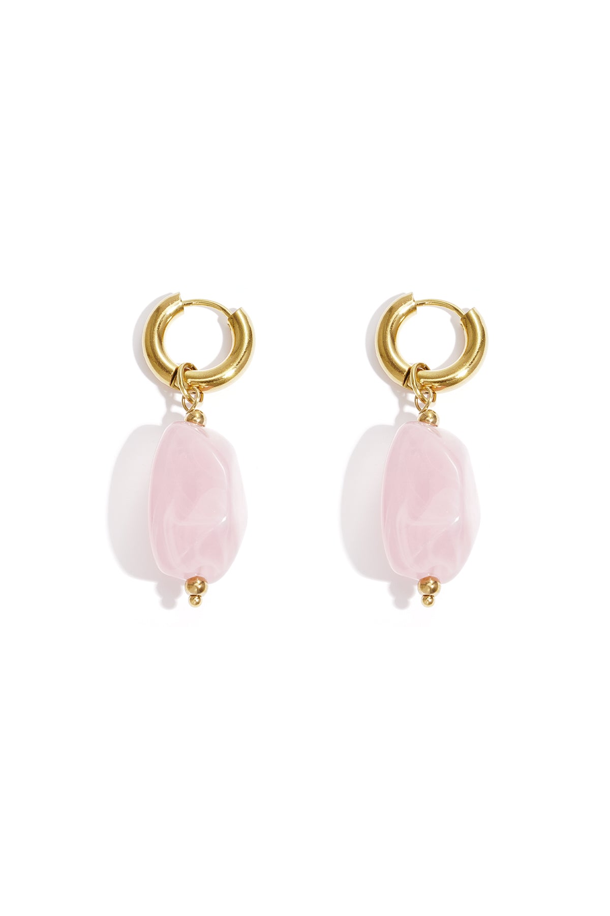 Gold hoop earrings with irregular blush pink resin drop beads on white background