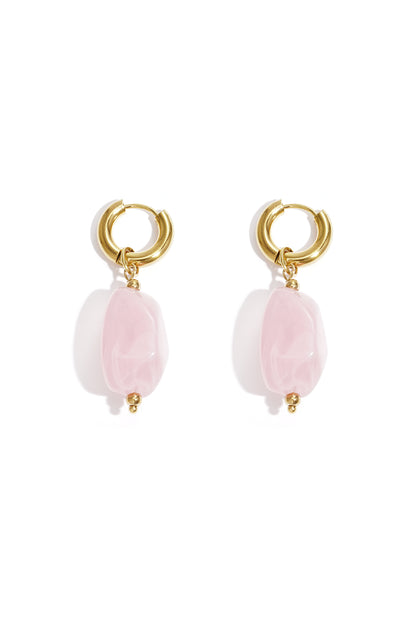 Gold hoop earrings with irregular blush pink resin drop beads on white background