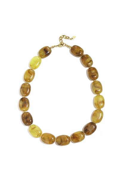 Close-up of amber marbled squoval bead necklace with gold clasp on white background