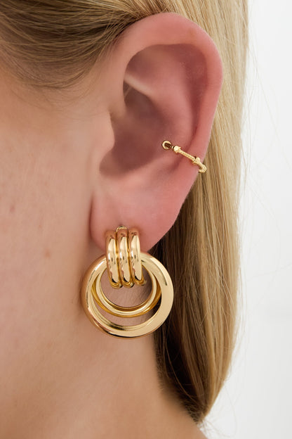 Close-up of ear wearing gold geometric ear cuff on upper ear