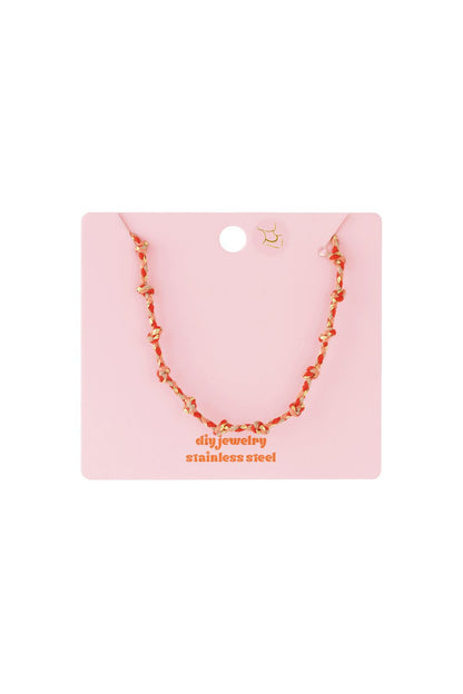 Soft Knot Aesthetic necklace: a delicate, knotted cord chain in mixed metallic and coral tones on a pink display card.