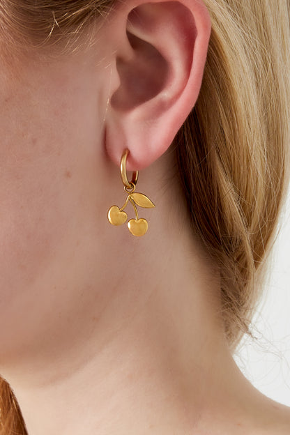 Close-up of a woman's ear wearing a gold-tone cherry charm drop earring showcasing its delicate design