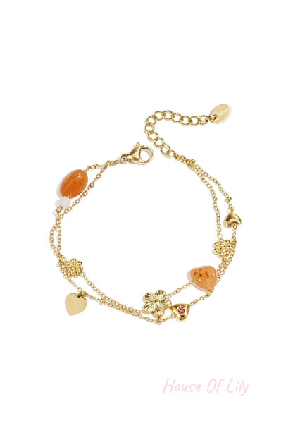 Charm bracelet with orange beads, flowers and hearts