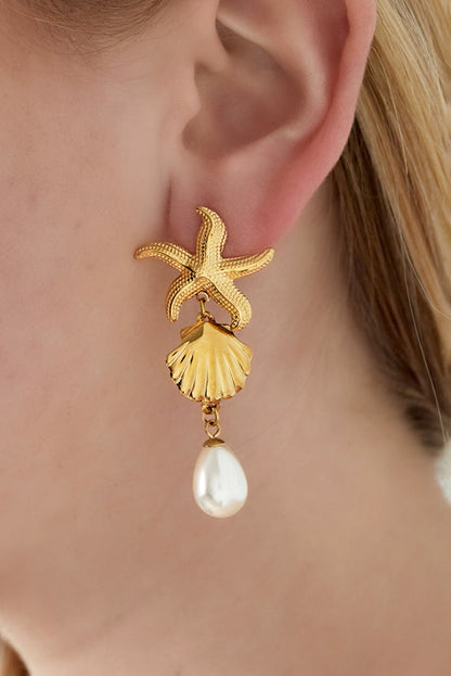 Close-up of gold starfish seashell earrings worn on ear with pearl drop