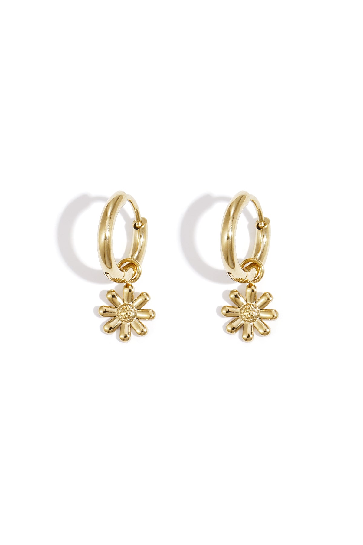 Pair of gold hoop earrings with dangling daisy flower charms on white background