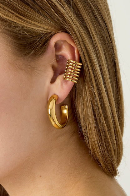 Side profile of model showing the layered gold-tone ear cuff and chunky hoop earring together on one ear.