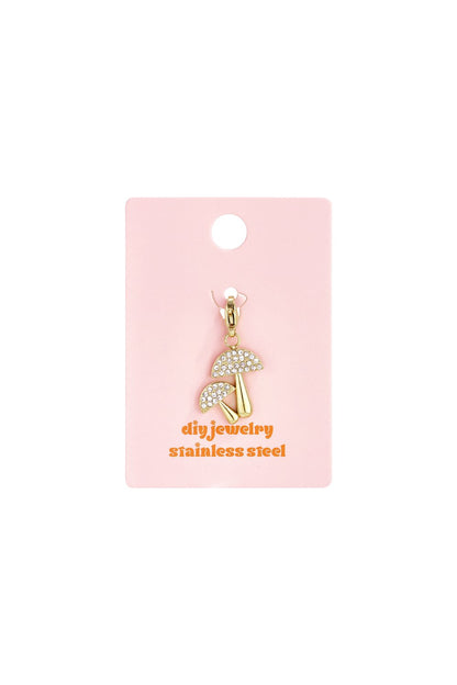 Gold-tone stainless steel mushroom charm featuring clear crystal-encrusted caps on a pink display card.