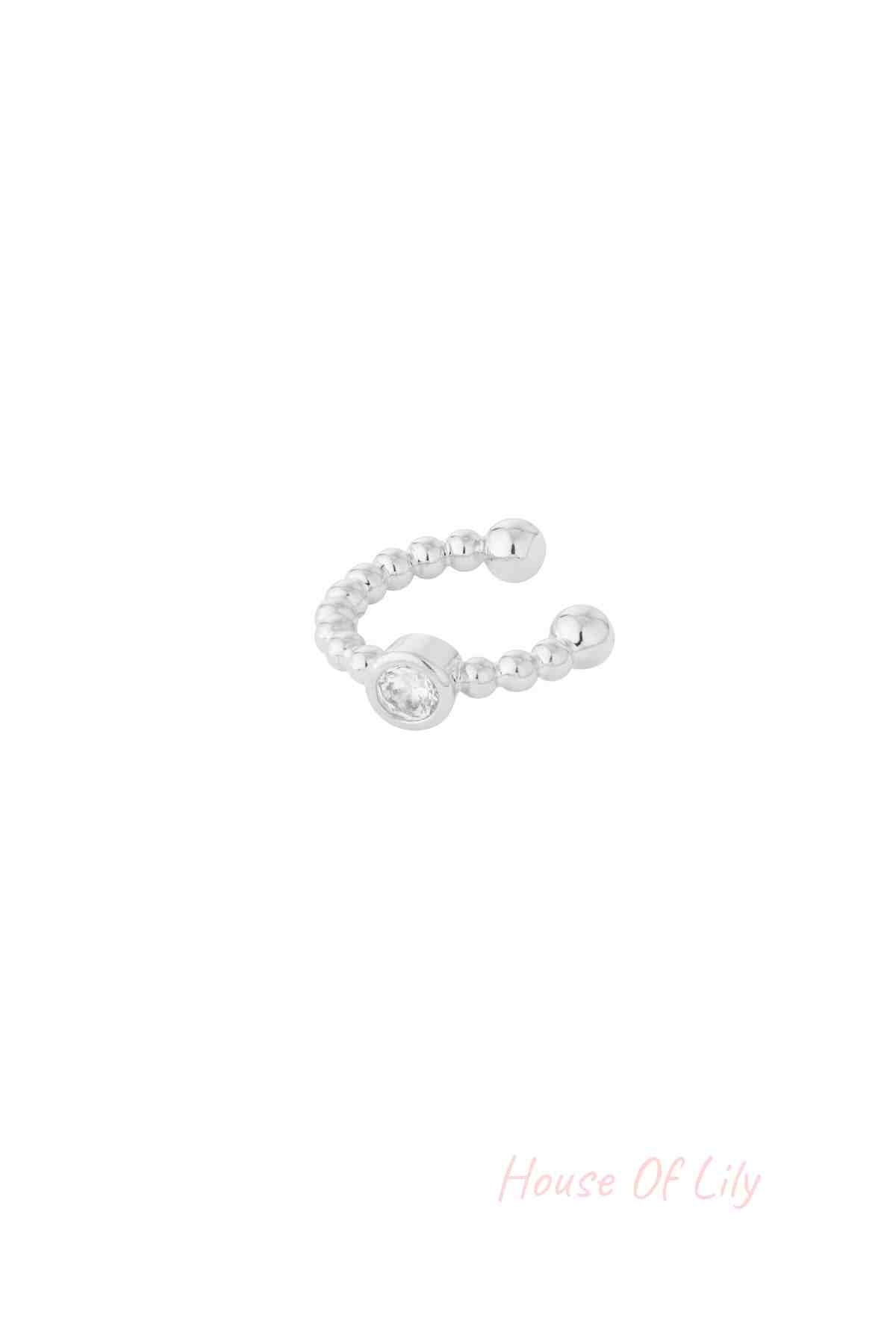 Close-up of a silver beaded ear cuff with a clear crystal centerpiece on white background