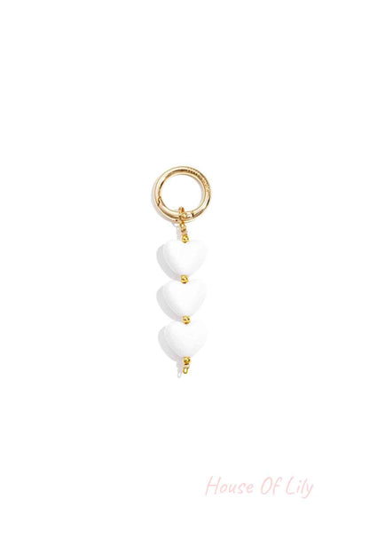 White acrylic heart charm bag keychain with gold-tone clasp on white background