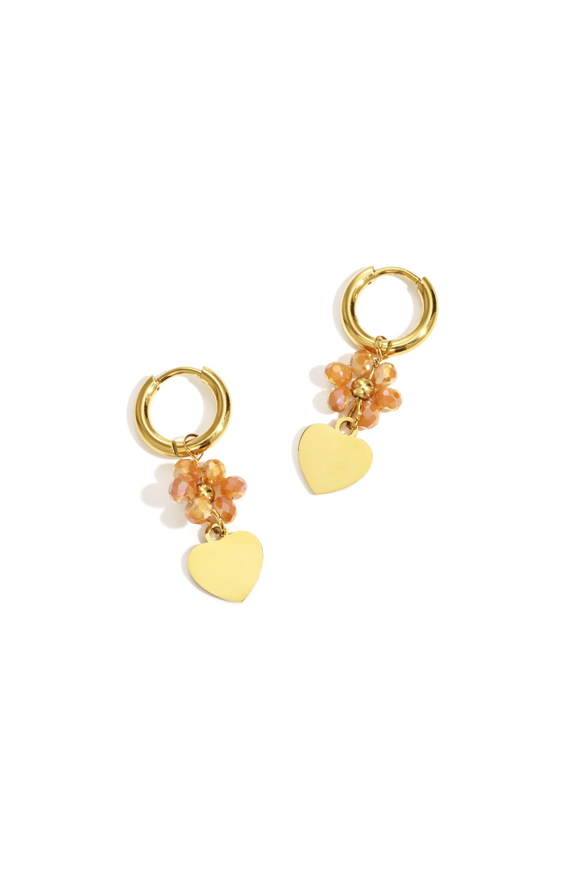 Pair of gold-tone hoop earrings with peach faceted beads and dangling gold heart charms on white background