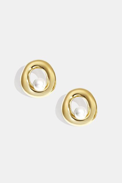 Pair of gold-tone circle stud earrings with pearl centerpiece on white background