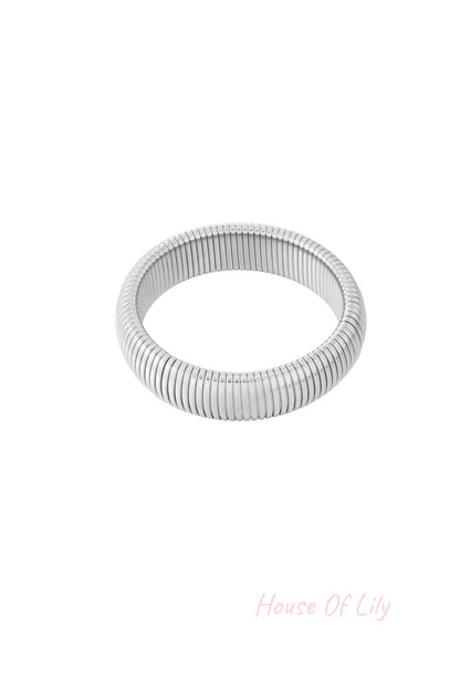 Close-up shot of a silver stretch bracelet with tubular segmented design on white background