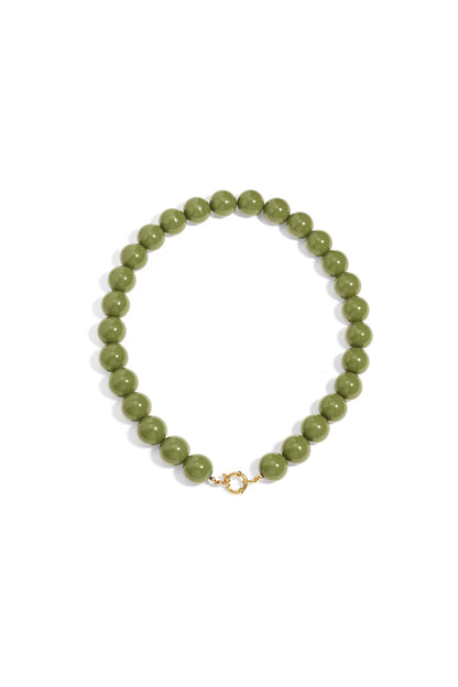 Chunky olive green resin bead necklace with a gold-tone circular front clasp, set against a plain white background.
