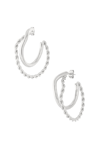 Pair of silver hoop earrings featuring one smooth and one twisted braided hoop, studio white background