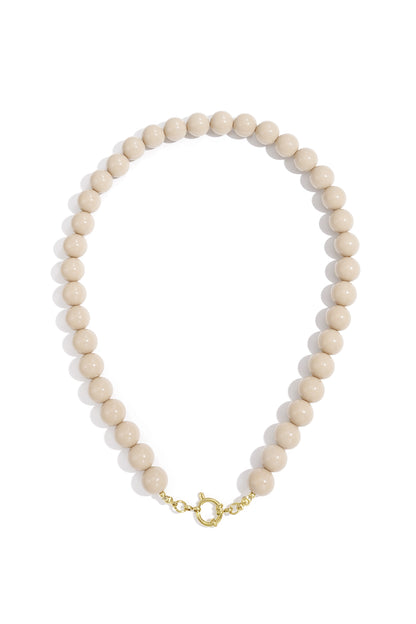 Beige resin beaded necklace featuring smooth, round beads and a gold-tone circular toggle clasp.