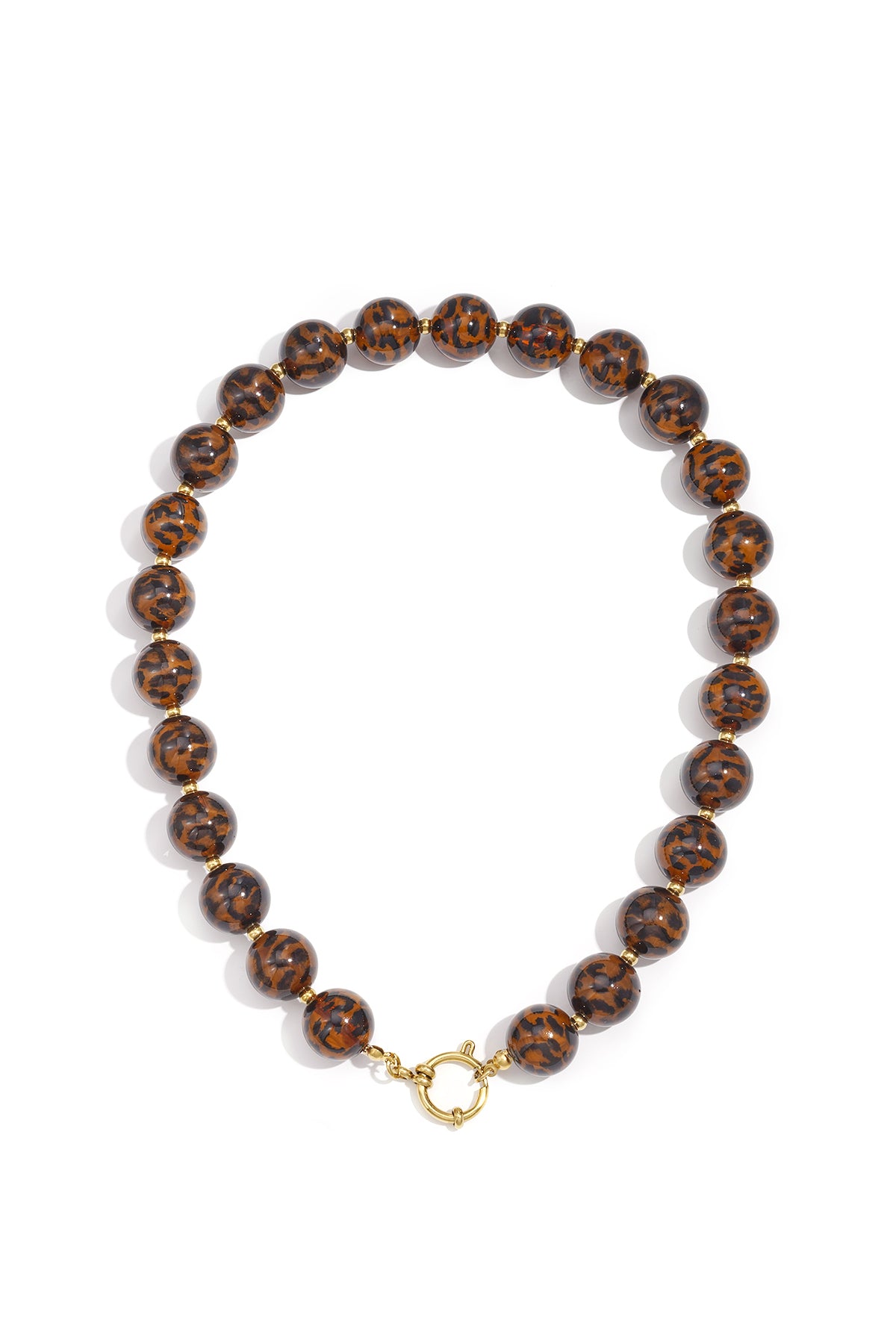Close-up of medium-length acrylic beaded necklace with leopard print beads and gold toggle clasp on white background