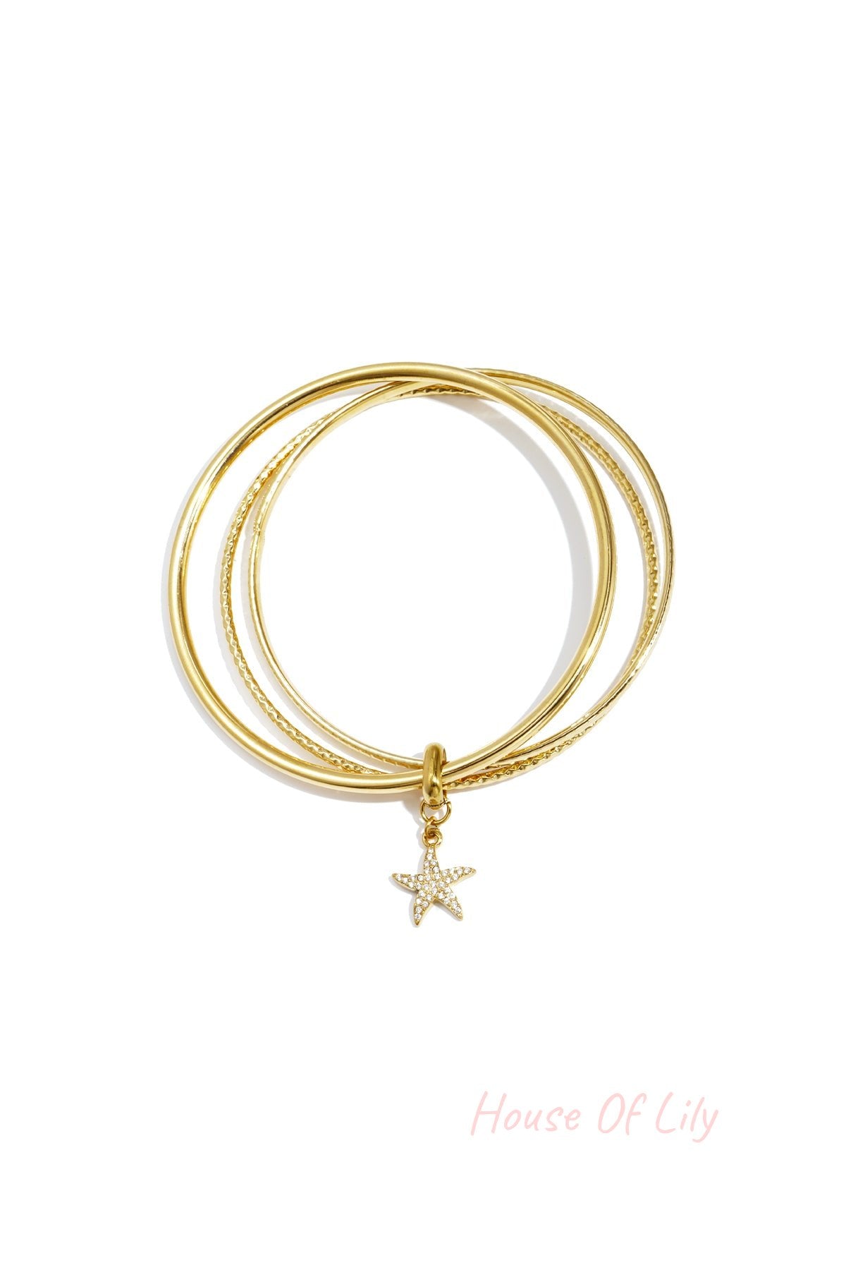 Two gold-tone bangles with a starfish charm adorned with rhinestones on a white background