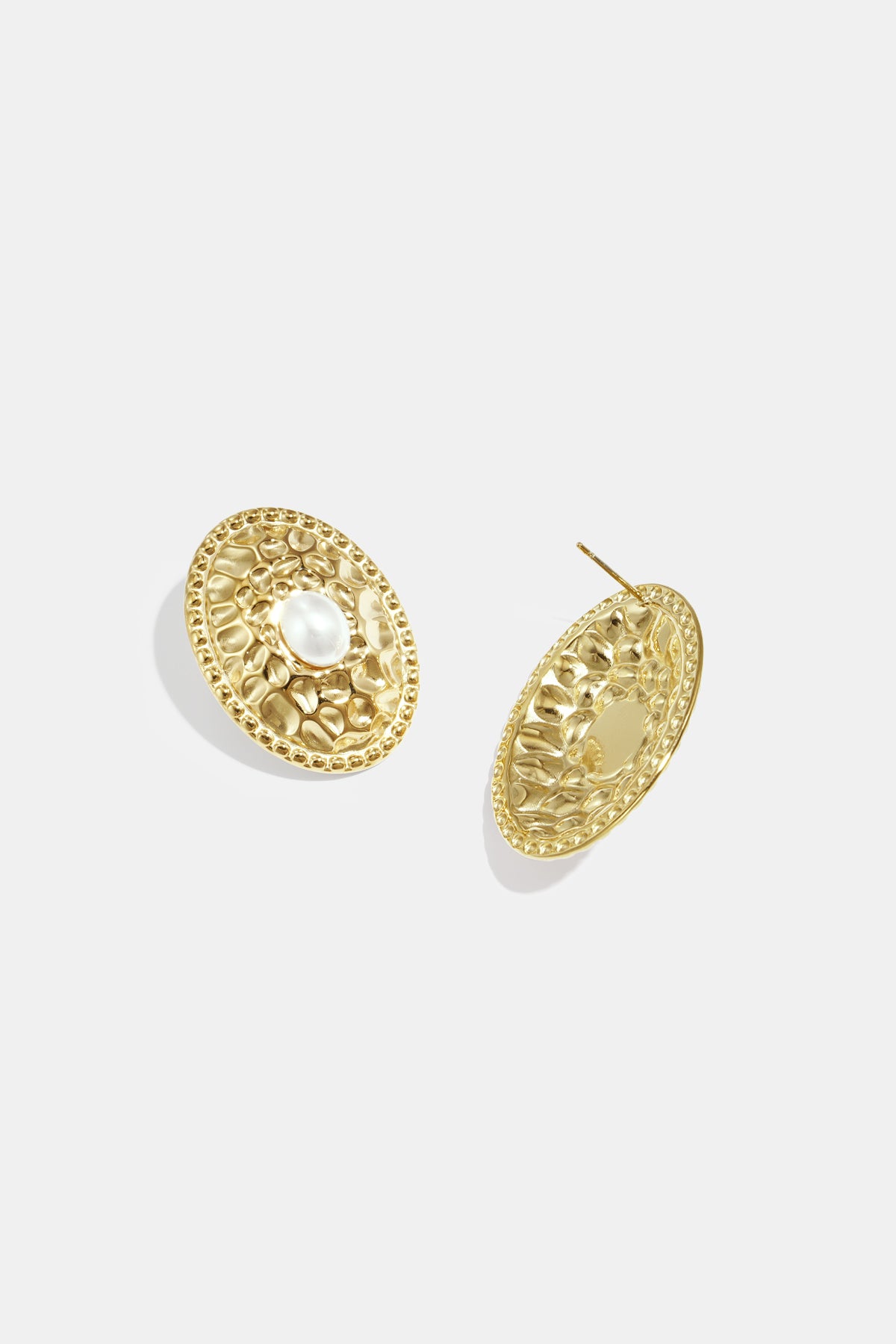 Pair of gold-tone oval stud earrings with hammered surface and pearl center showing front and back views on white background