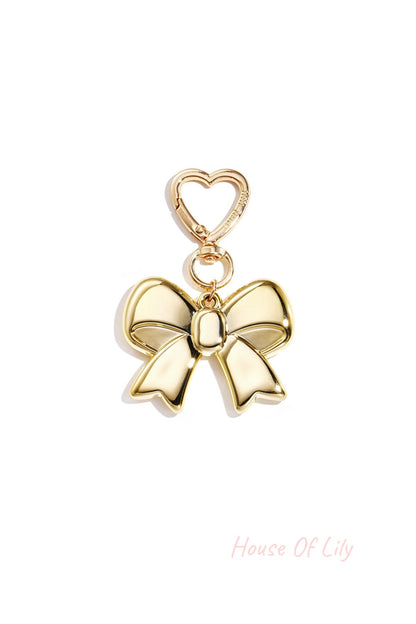 Gold metallic bow keychain with heart-shaped gold clasp on white background