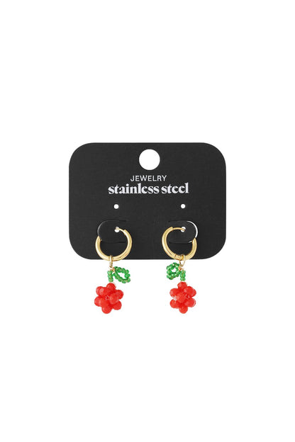 Gold hoop earrings featuring beaded red cherry charms with green leaves, displayed on a stainless steel jewelry card.