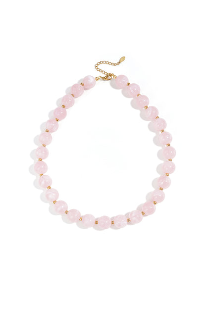 Light pink marbled beaded necklace featuring round beads separated by small gold-tone spacers on a gold chain.