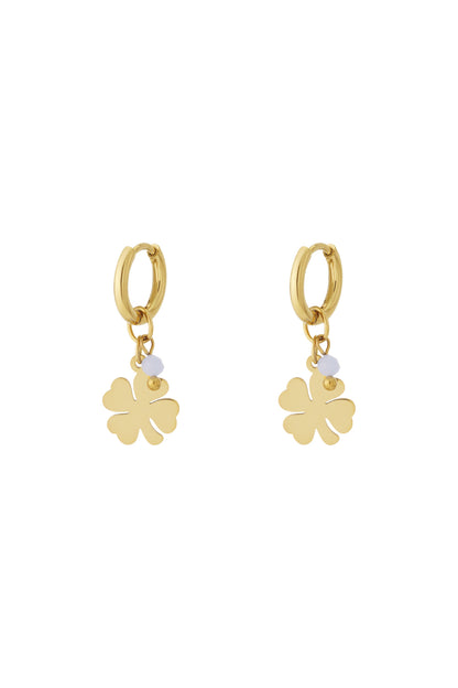 Pair of gold-plated drop earrings featuring four-leaf clover charm with white bead accent on white background